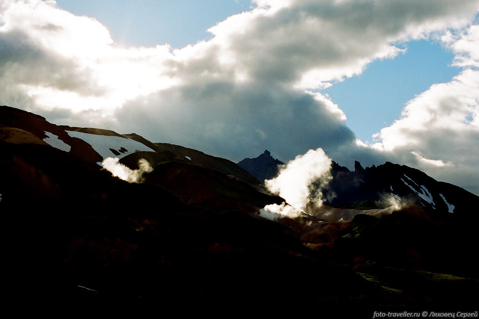 Лучи солнца освещают клубы пара над термальной площадкой "Верхнее 
поле" вулкана Бурлящий.