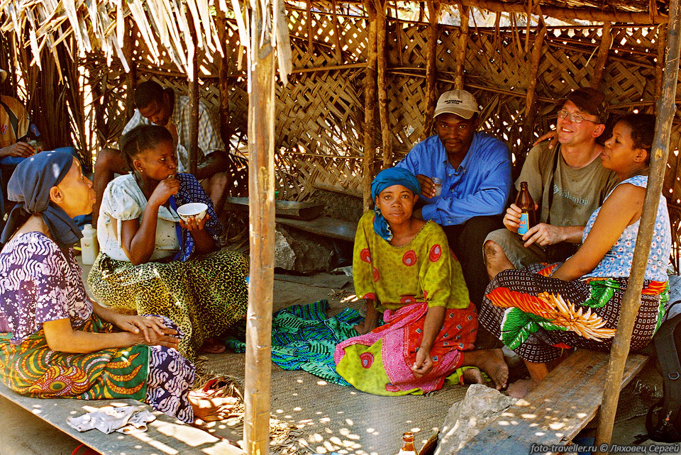 Дема попивает самодельное кокосовое пиво в гостях у деревенских 
жителей