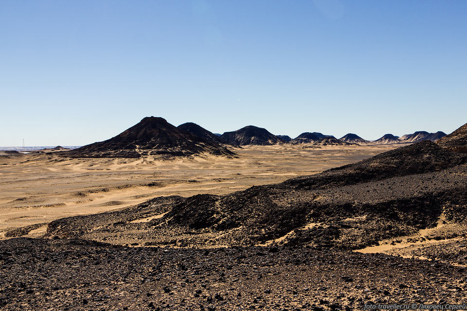 Черные камни прекрасно контрастируют с песком - пейзажи в Черной 
пустыне контрастные