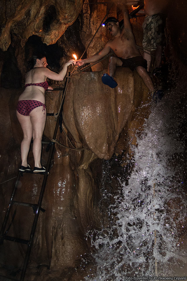 Гид помогает залезть на водопад - держит свечку
