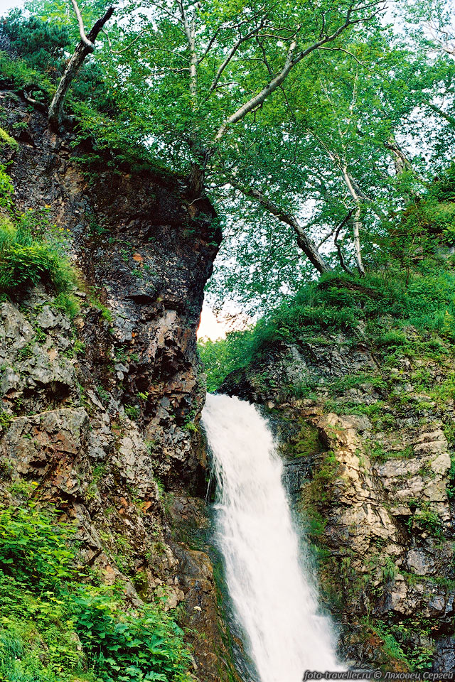Красивый водопад высотой 20 м, падающий из под берез
