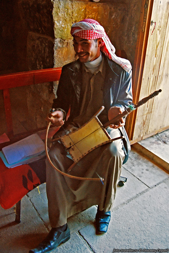 Смотритель замка играет на местном музыкальном инструменте - рабабе.