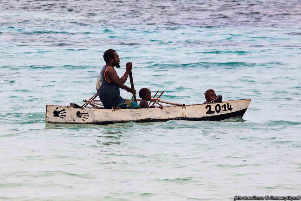 Вануатец катает своих детей на лодке