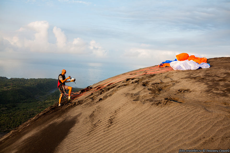 Парапланерист Жан-Марк из Франции готовится к полету с кромки 
вулкана Ясур